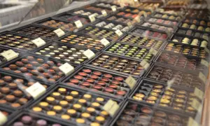 Wybór pralin w pijalni czekolady Kraków. Różnorodne smaki i kolory czekoladek kuszą zza szyby.