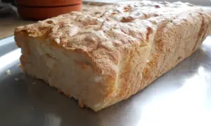Puszyste ciasto z białek i kokosu, lekko zarumienione, na metalowej tacy.