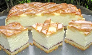 Pyszny sernik z dżemem, polany lukrem, pokrojony na kawałki. Idealny na deser.