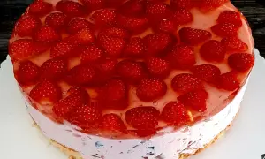 Pyszne ciasto kryształek bez pieczenia, obficie udekorowane świeżymi truskawkami w galaretce. Idealne na letnie popołudnie.