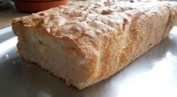 Puszyste ciasto z białek i kokosu, lekko zarumienione, na metalowej tacy.