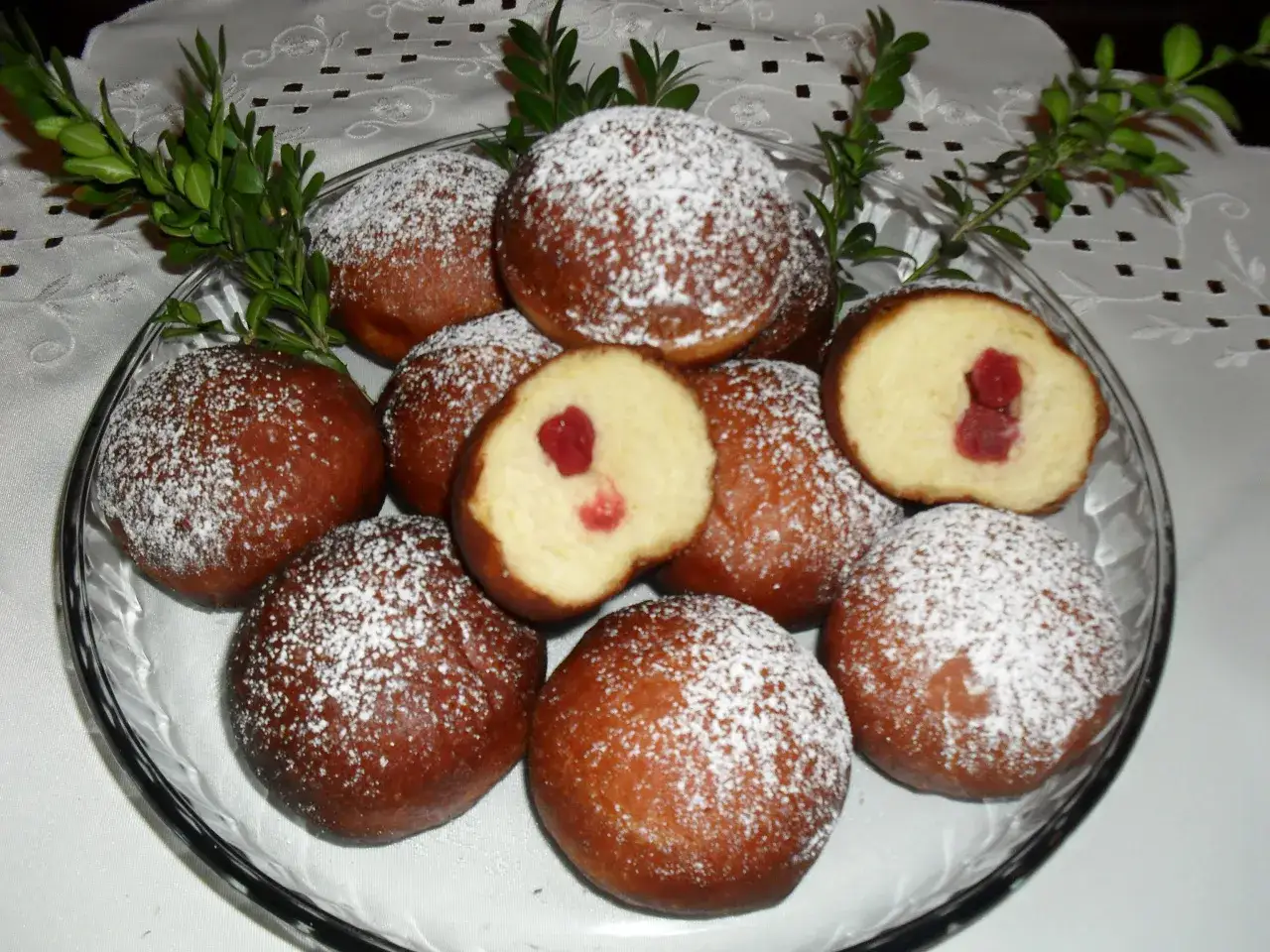 Pyszne pączki z piwem, oprószone cukrem pudrem, z widocznym nadzieniem z konfitury. Idealne na tłusty czwartek.