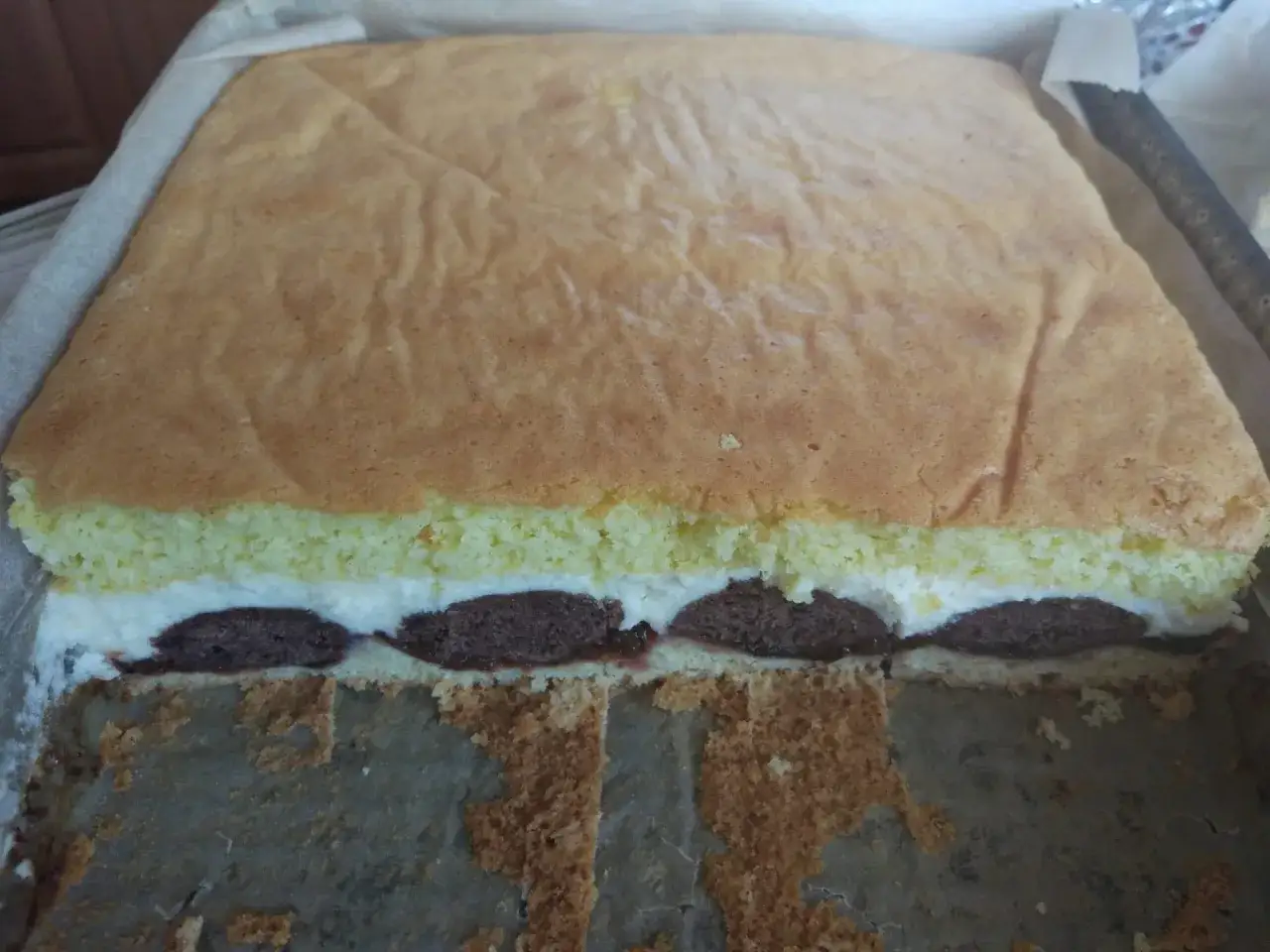 Ciasto pawie oczko z kremem i czekoladowymi kropkami, gotowe do krojenia.