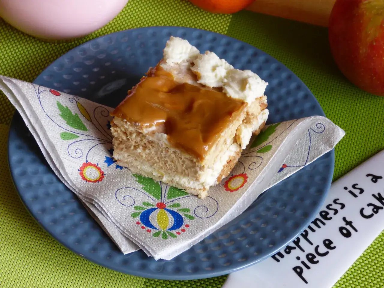 Pyszne ciasto kajmakowe przepis na talerzyku, udekorowane bitą śmietaną i polewą karmelową. Idealne na deser!