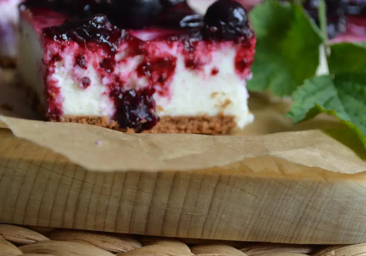 Pyszny porzeczkowiec na kruchym spodzie z herbatników, polany gęstą konfiturą z porzeczek.