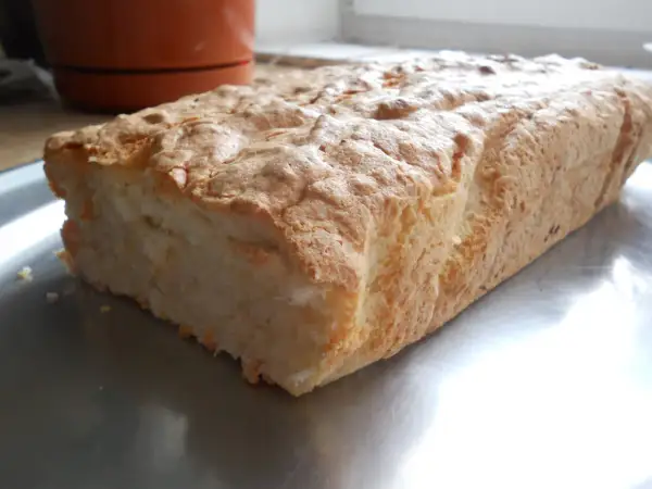 Puszyste ciasto z białek i kokosu, lekko zarumienione, na metalowej tacy.
