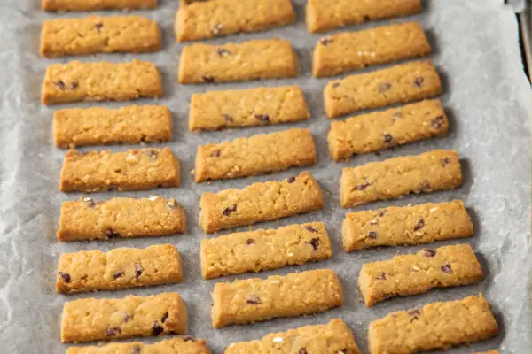 Ciasteczka Belvita na papierze do pieczenia. Czy ciastka Belvita są zdrowe? Te złociste, prostokątne herbatniki z kawałkami czekolady i owoców wyglądają apetycznie.